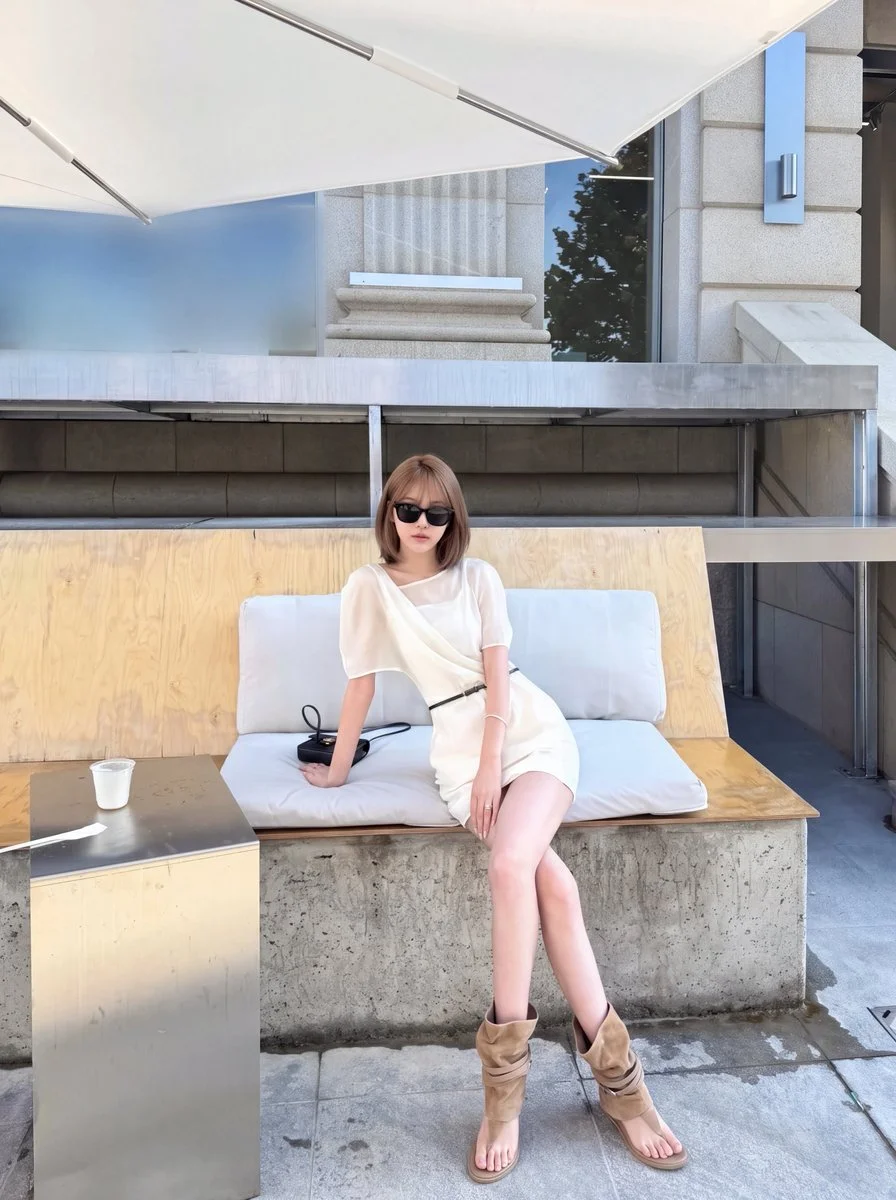 Tan Suede Boots Ground a Draped White Dress on a Sunny Terrace
