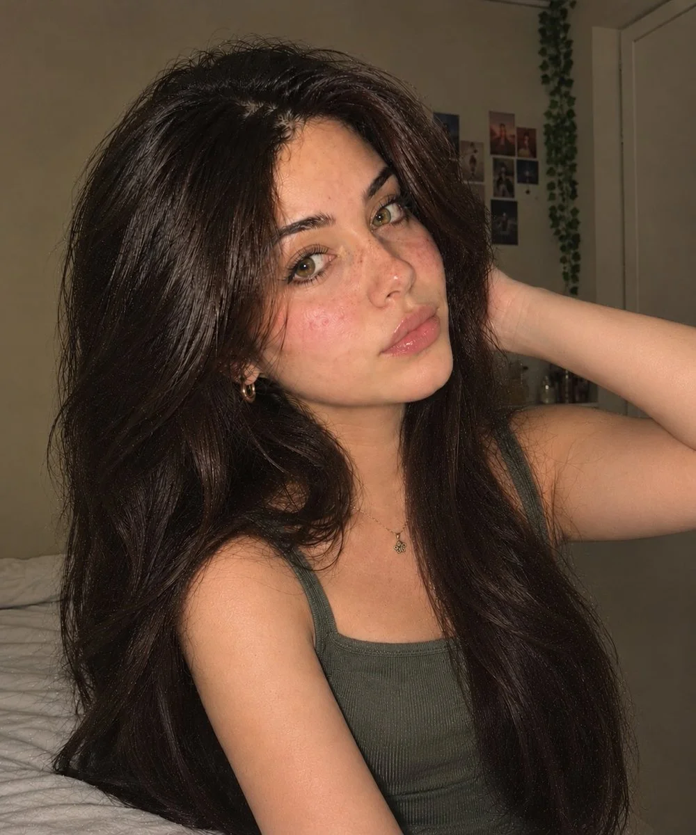 Warm bedroom portrait of a woman with tousled dark hair