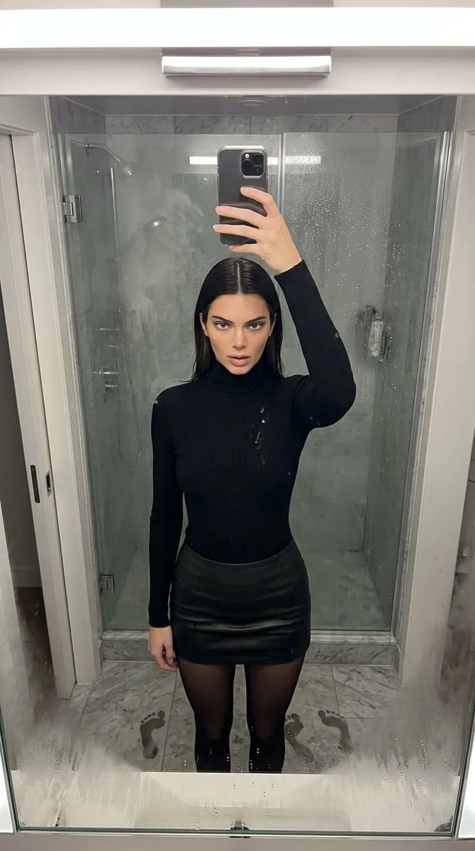 Water droplets frame Kendall Jenner's reflection in a steamy bathroom