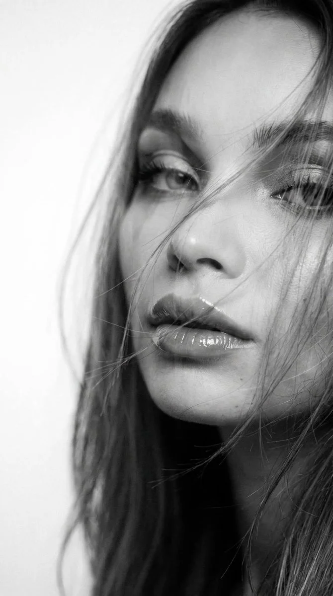 Wind-swept woman with glossy lips in dreamy double exposure