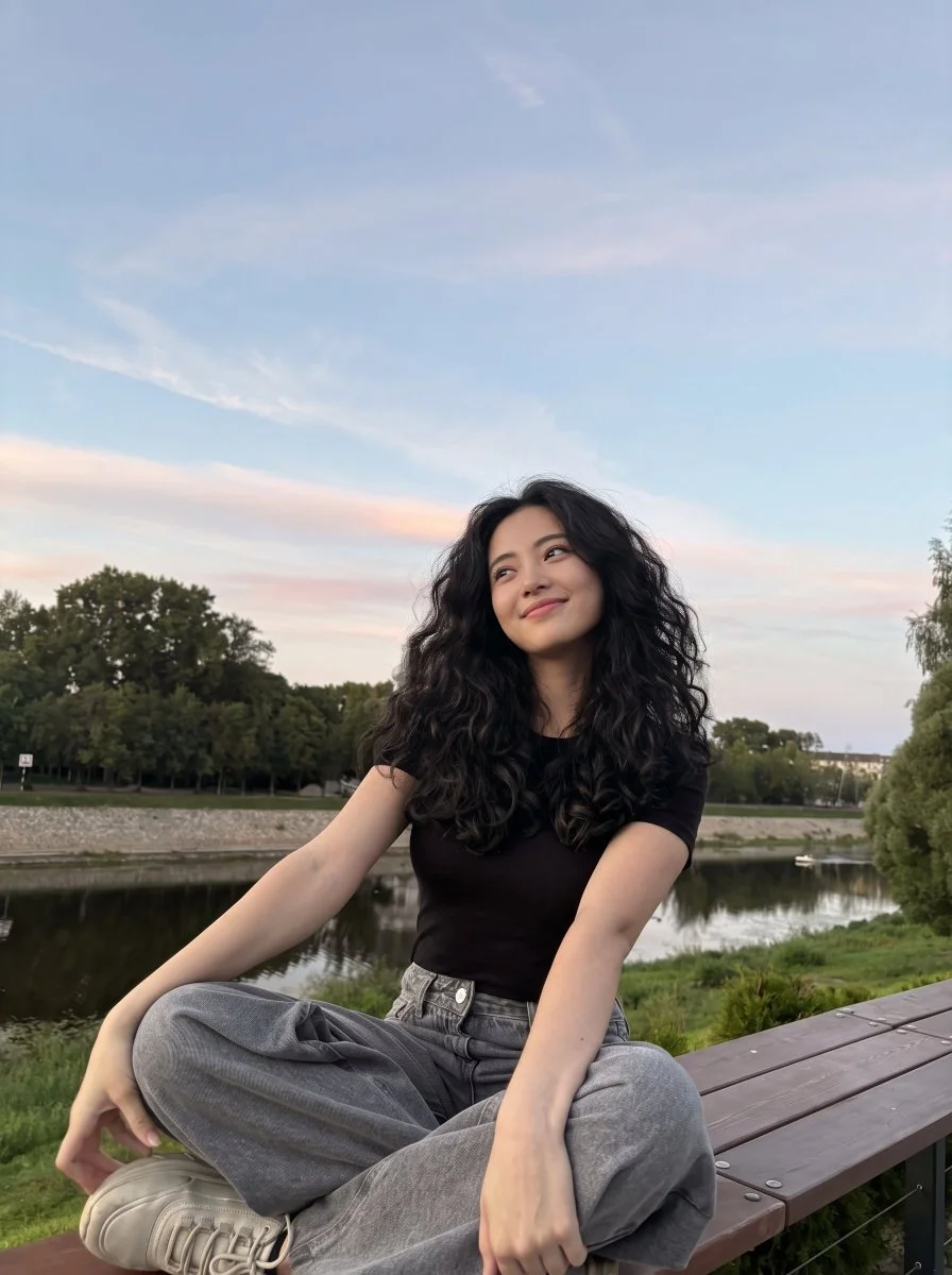Woman in baggy denim smiles during golden hour on bench
