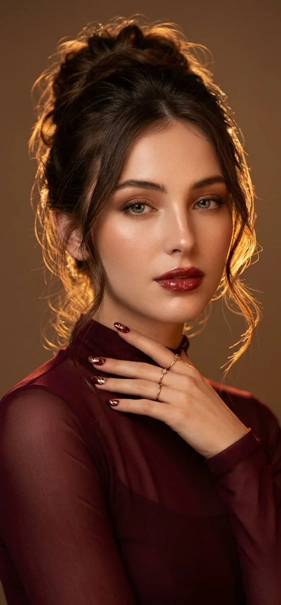 Woman in burgundy sheer outfit poses with golden rim light portrait