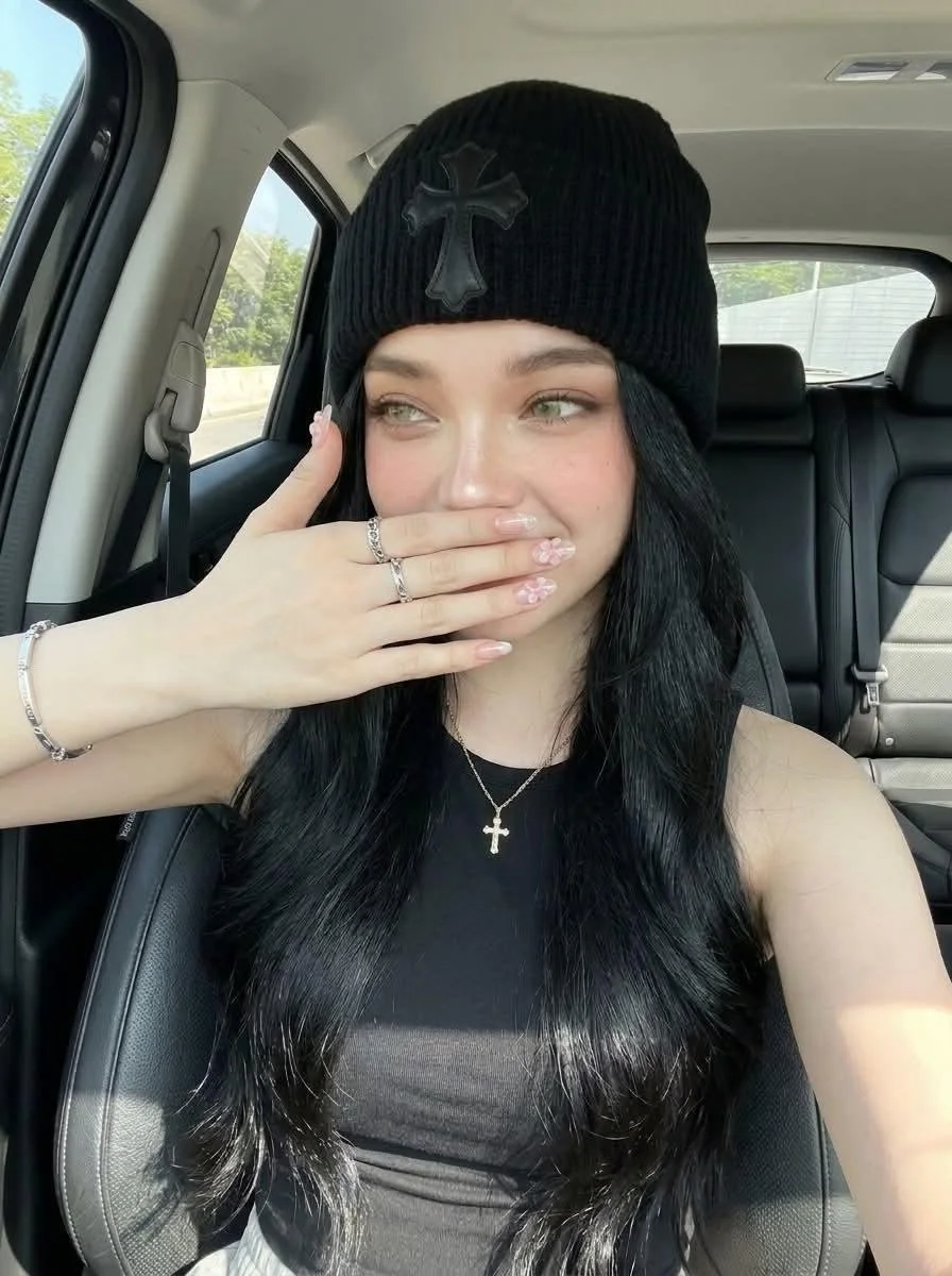 Woman in luxury car poses with floral nail art in selfie