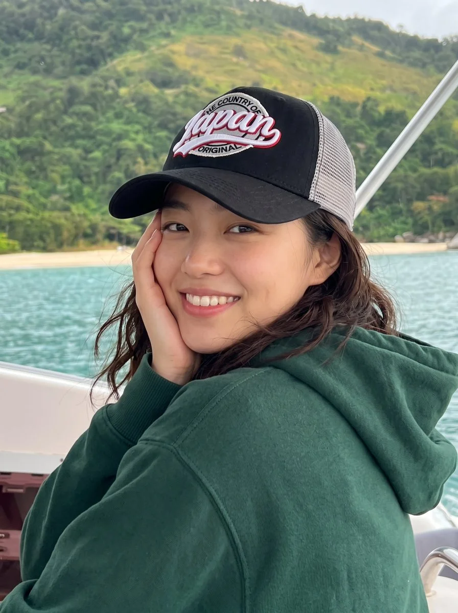 Woman in 'The Country of Japan' Hat Smiles on Tropical Boat