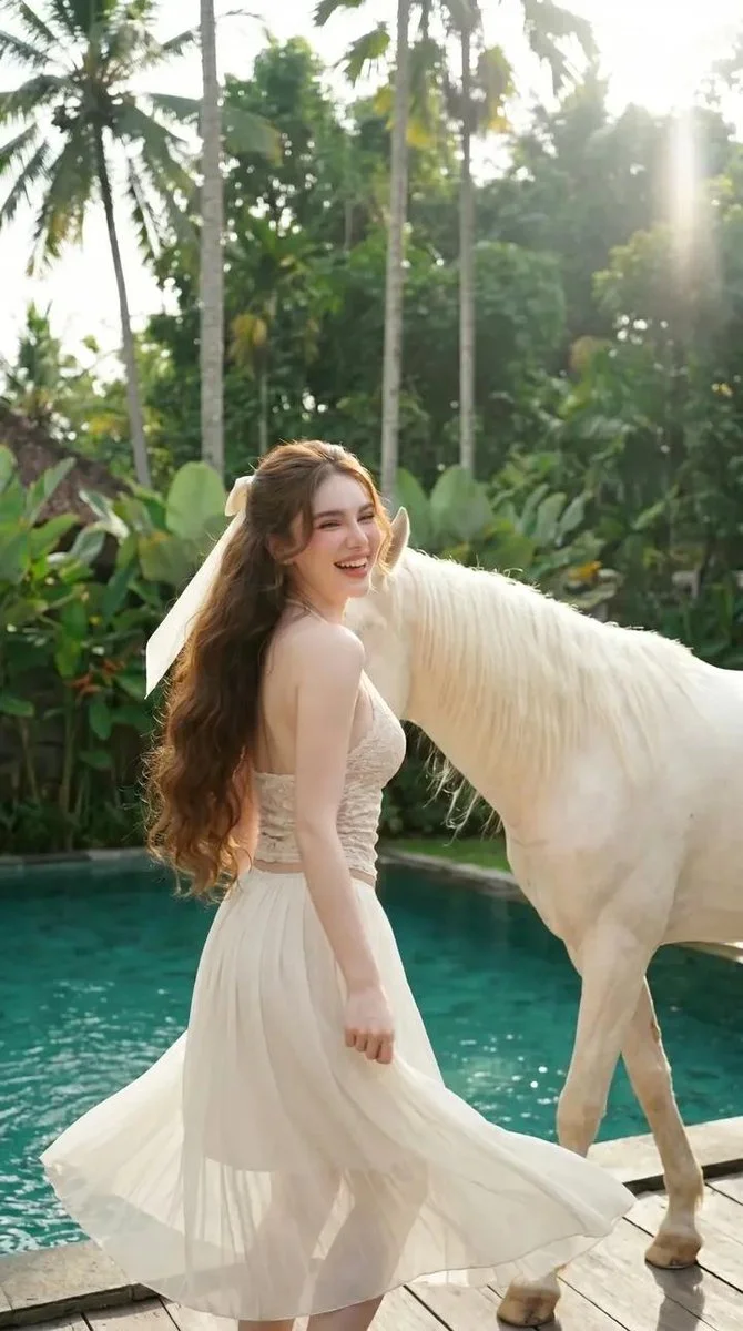Woman in white lace touches a white horse by a pool