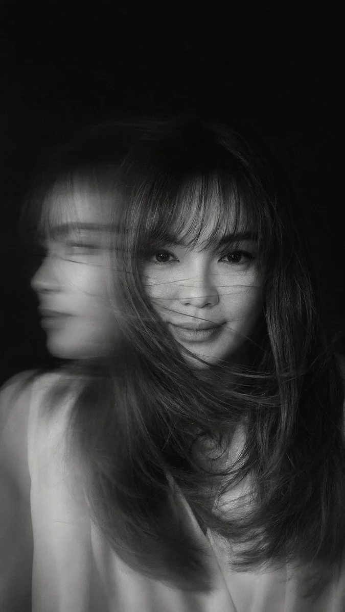 Woman's blurred face emerges from sweeping hair in motion