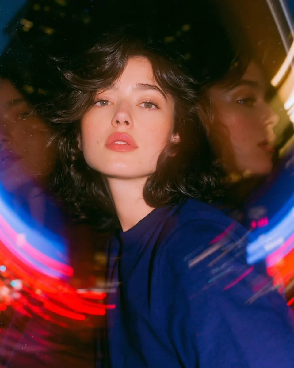 Woman's clear face amid swirling reflections in a rotating glass door