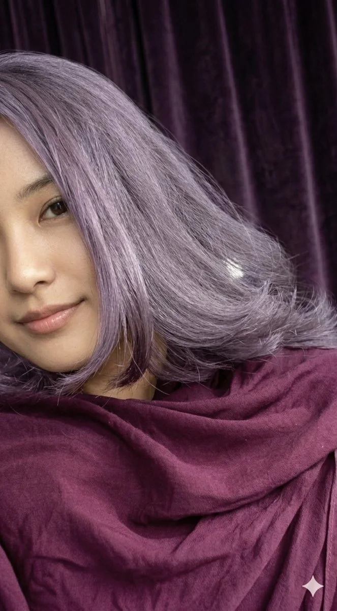 Woman with lavender hair smiles softly in purple velvet light