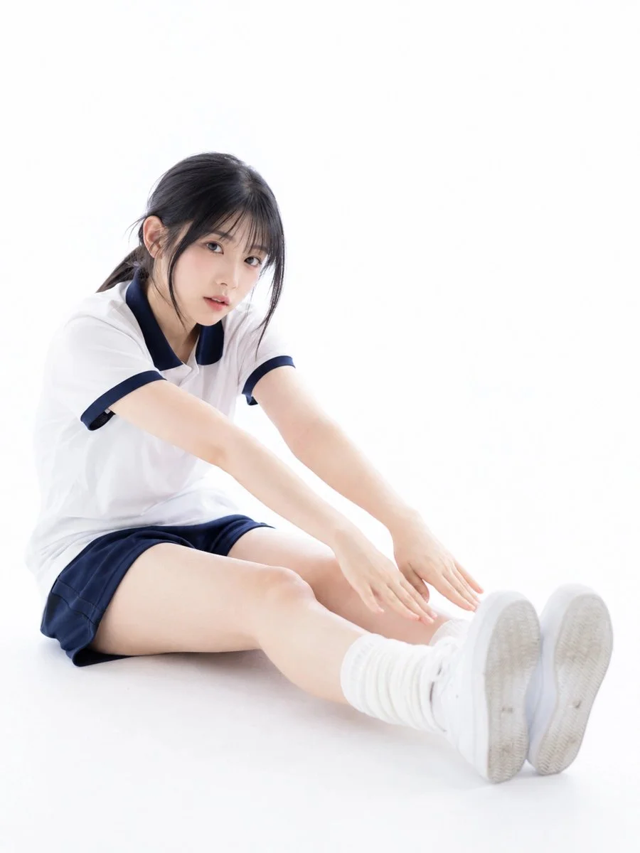 Young athlete stretches in a sunlit white studio portrait