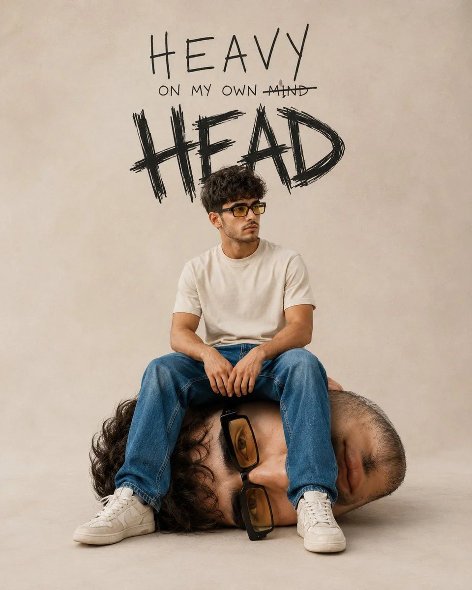Young man sits on his own giant head in surreal portrait