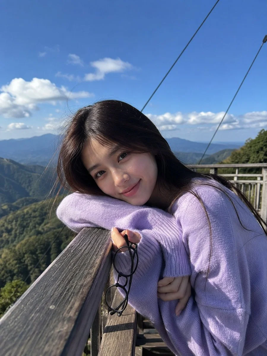 Young woman in lavender sweater poses at mountain viewpoint