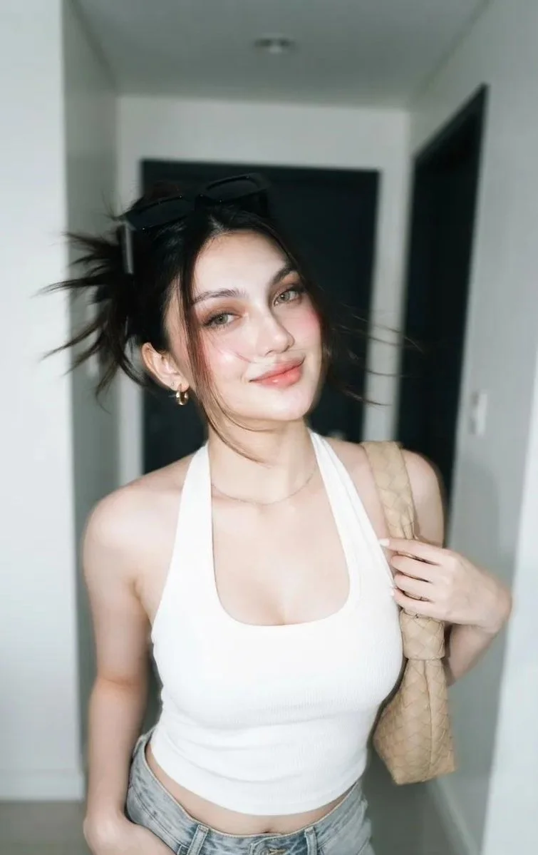 Young woman in motion blur poses with white halter top