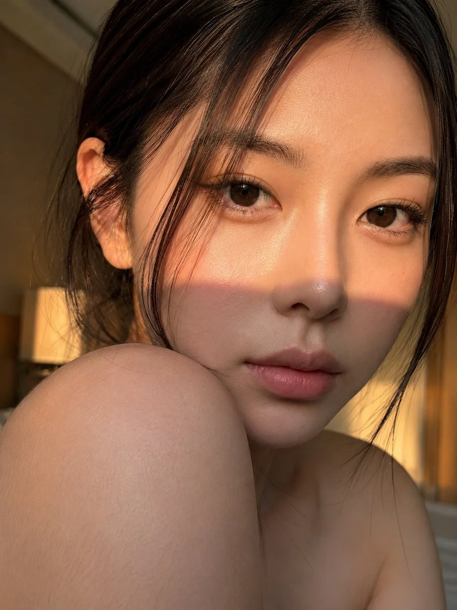 Young woman with bare shoulder turns head in golden hour light